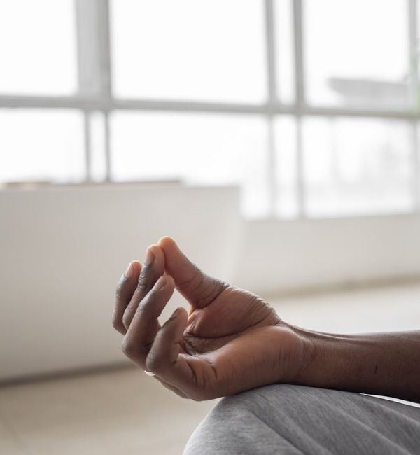 Person meditating peacefully in a calm, minimalist setting.
